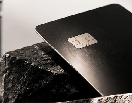 A dark payment card resting on stone.